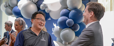 UNF employees conversating and laughing at an employee mixer