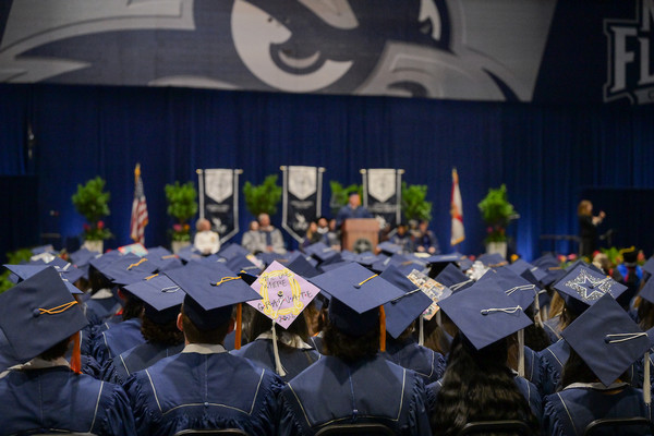UNF students in cap and gown seated at commencement