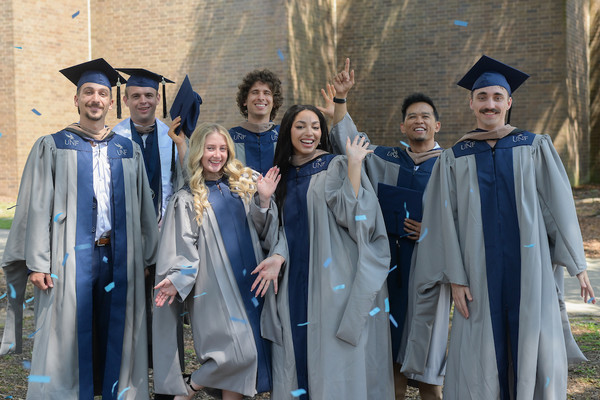 Group of UNF grad school students at commencement in cap and gown