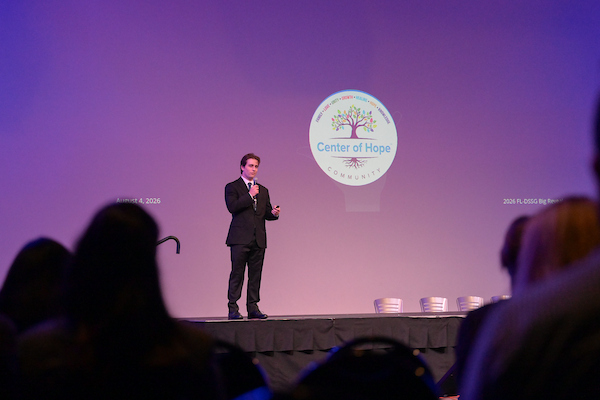 Student on stage speaking at the FL-DSSG "The Big Reveal" 2026