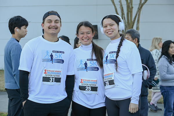 Three people standing together at Swoop the Loop 2026 event