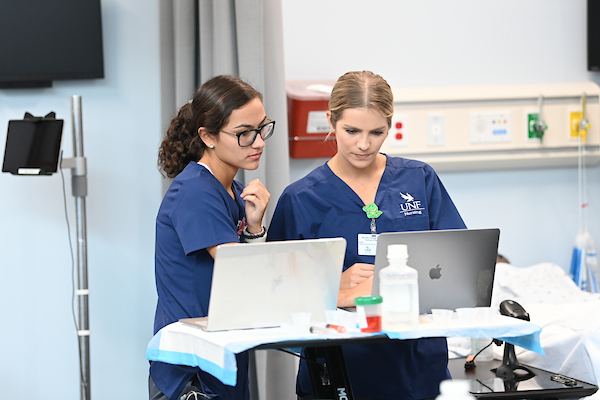 Two female UNF nursing students viewing information on a laptop