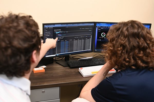 Two male UNF ITS team members looking at computer monitors