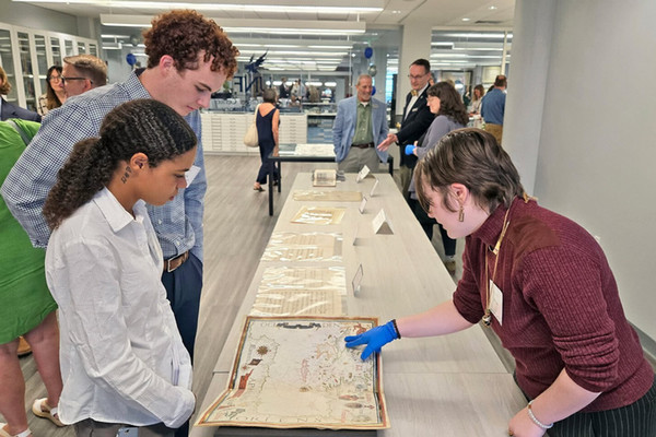 People viewing a map on a table in the Allen Lastinger Center for Florida History