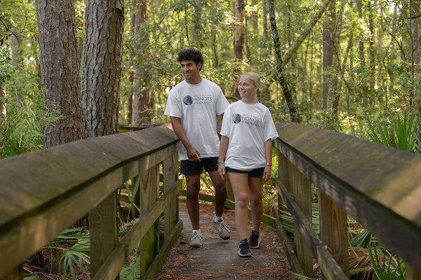 UNF students walking through a nature trail platform