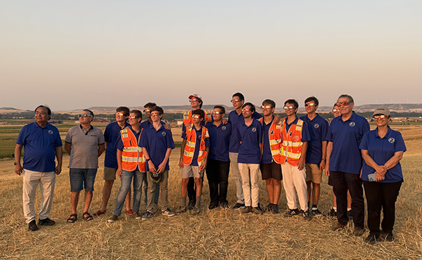 UNF NASA team standing in a field looking toward the sky