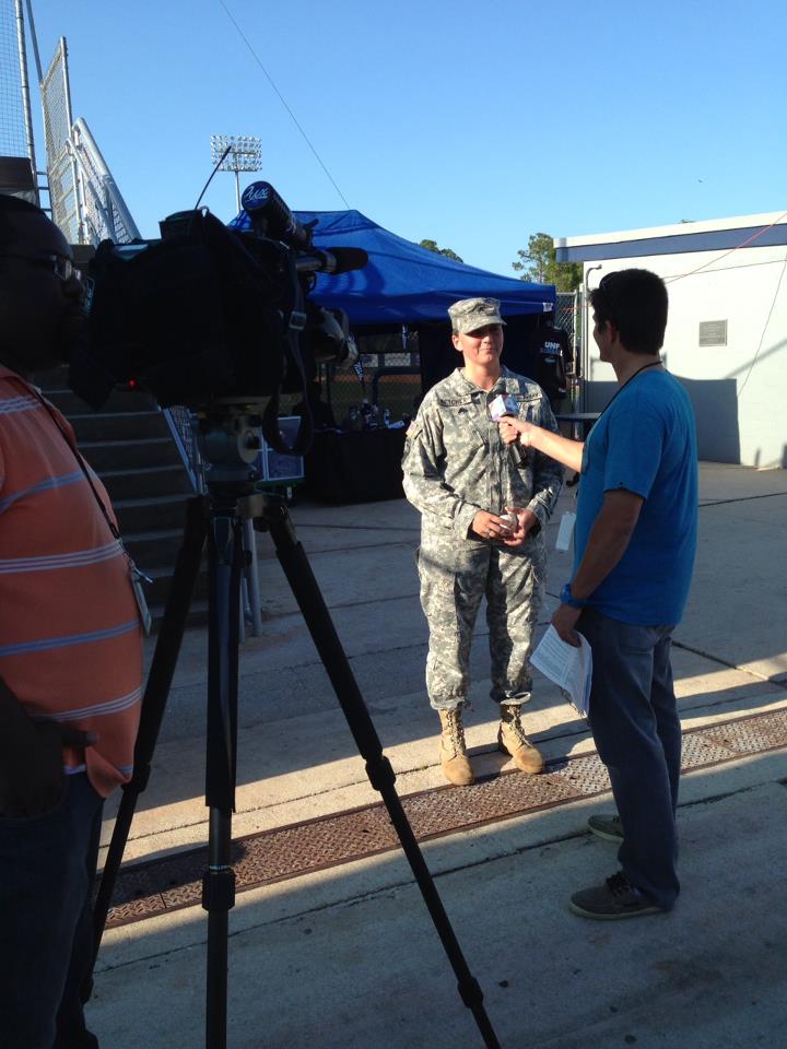 Rebecca speaking to a news reporter while in uniform