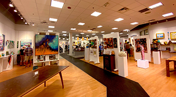 Overview shot of the ARTSee & Shop Gallery featuring various paintings and prints