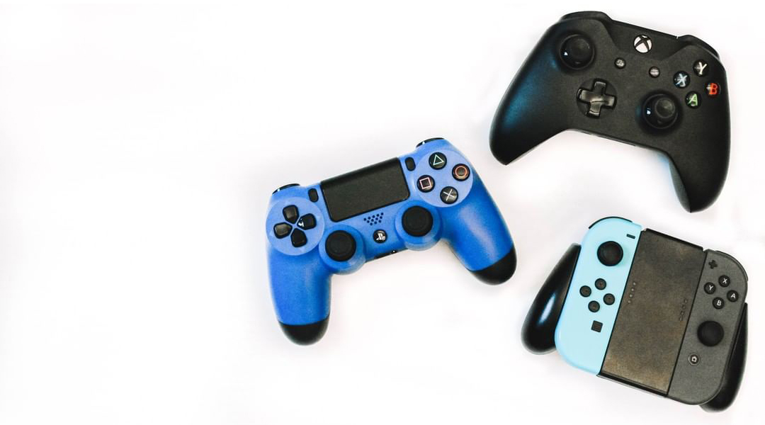 A PlayStation 4, Xbox One, and Nintendo Switch controller on a white background