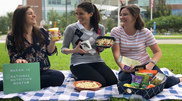 UNF dietitians sitting on a picnic blanket eating healthy snacks