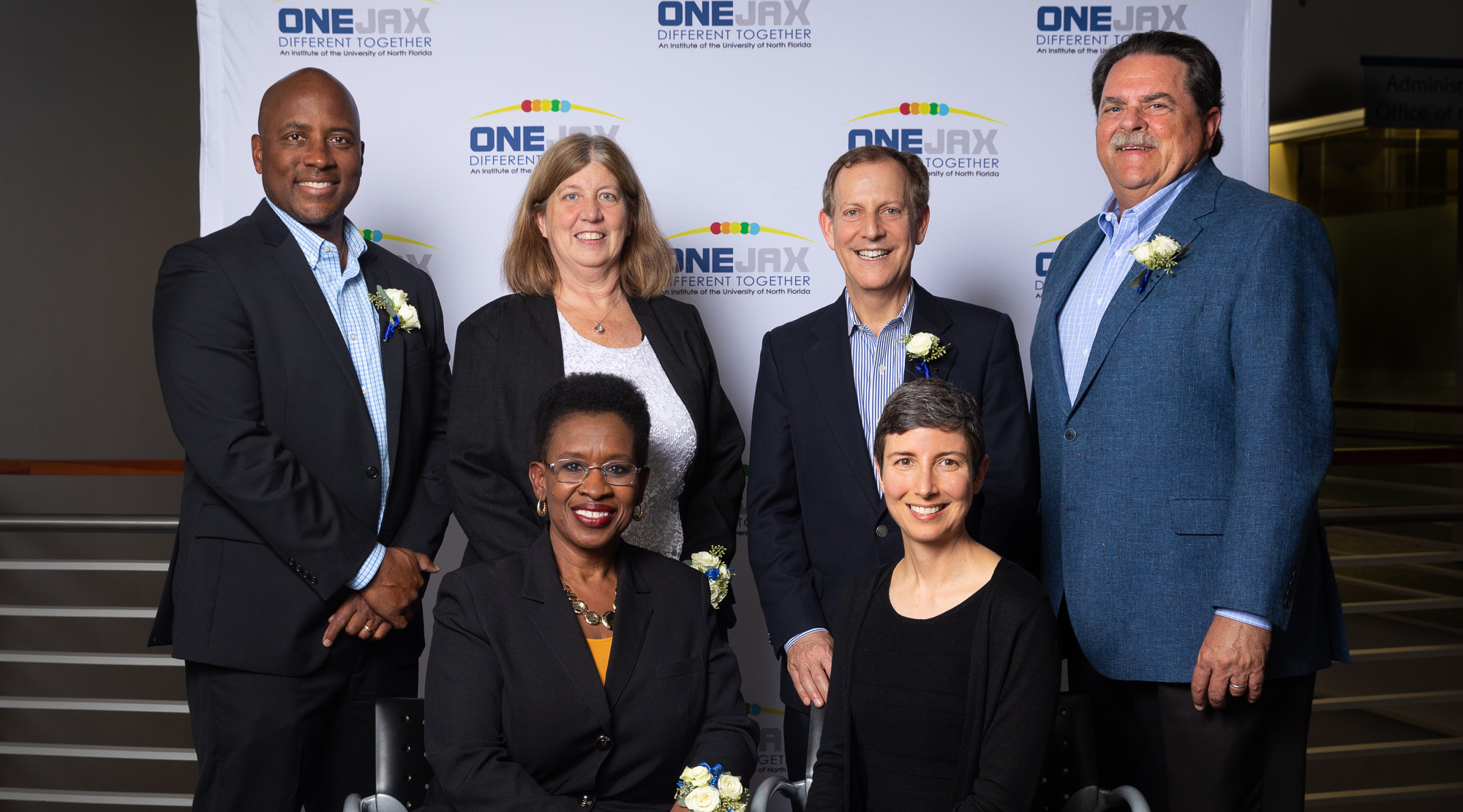 OneJax Humanitarian Award Honorees standing together against a OneJax backdrop