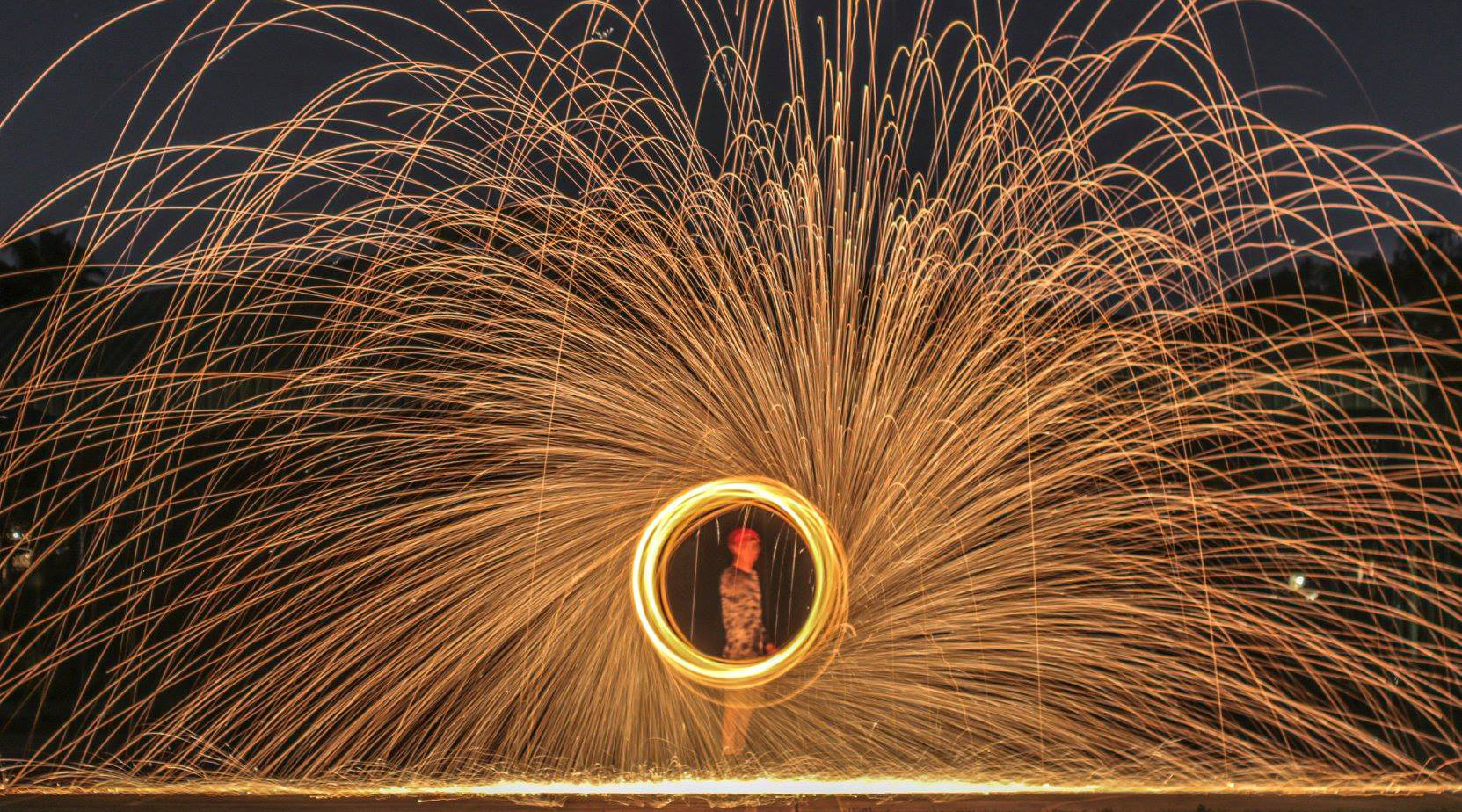 Lighting steel wool on fire and swinging it in circles to create an elaborate display of light