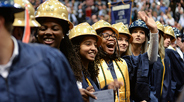 Smiling students with construction hats at graduation