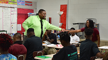 Black male teacher engaging with students in a classroom