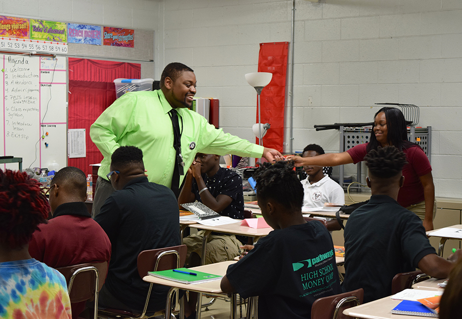 Black male teacher engaging with students in a classroom