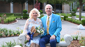 President and First Lady Szymanski sitting on a stone bench in the Healing Garden