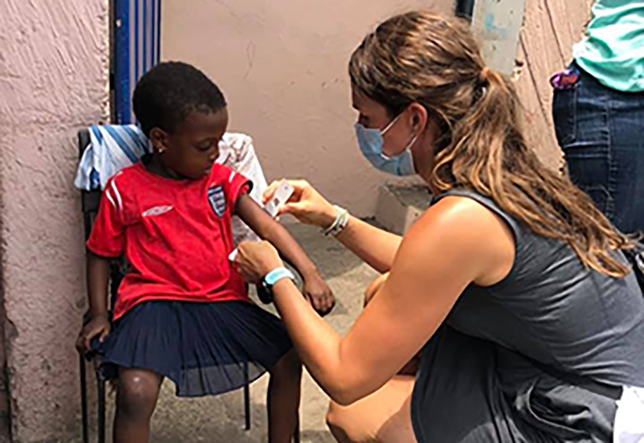 Students giving nutrition assessments to child in Ghana