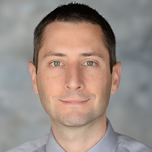 Headshot of Dr. Josh Melko on a grey background
