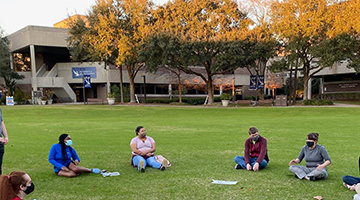 OCT program students sitting in a socially distanced circle on the UNF Green 