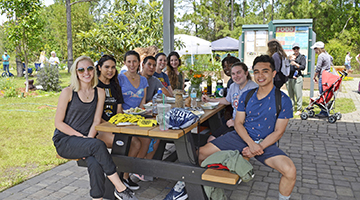 UNF students sitting around a picnic table in the Ogier Gardens