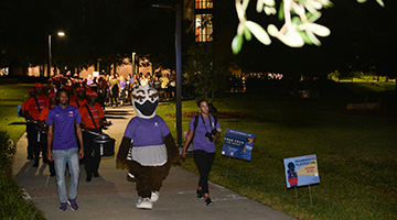Ozzie and students in purple shirts marching in the Take Back the Night event