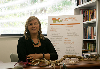 Dr. Denise Bossy in her office with Indigenous artifacts 
