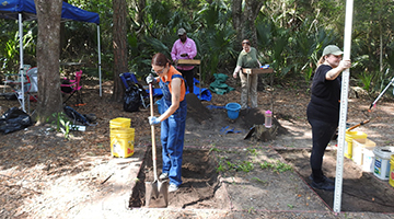 archaeology students digging in the field