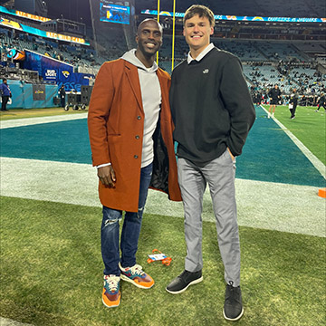 Brady Okla posing with former NFL cornerback Jason McCourty on Everbank Field