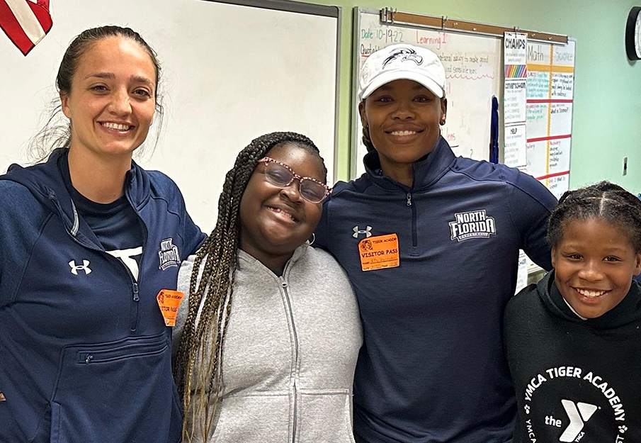 Two of CAMP Osprey's mentors posing beside two students