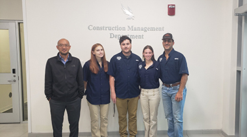 The Construction Management Ethics Team posing in front of the UNF 'Construction Management Department' sign.