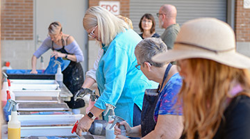 Participants of the Combat Paper workshop creating paper from clothing pulp