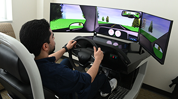 A professor demonstrating what a drive looks like using the Department of Psychology's new Driving Simulator