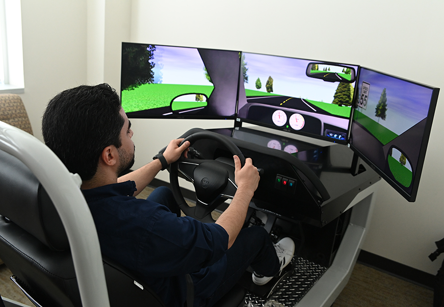 A professor demonstrating what a drive looks like using the Department of Psychology's new Driving Simulator