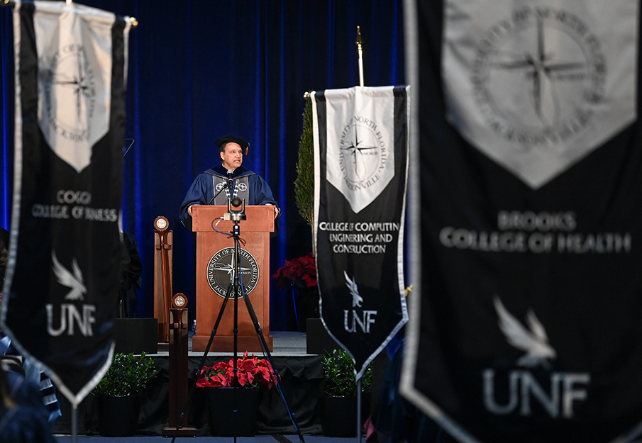 President Moez Limayem standing behind a podium at commencement