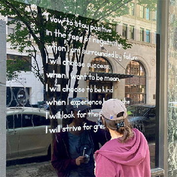 A lady writing a poem on a storefront window