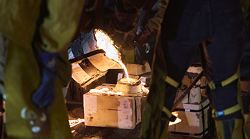 Students pouring iron into a mold