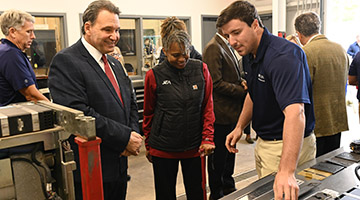 UNF-JEA employee showing President Limayem and JEA Chief Operating Officer Raynetta Curry Marshall machinery in the new Sustainable Solutions lab