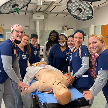 Mia Scarcella with members of the Palm Coast Cohort surrounding a dummy for a medical class