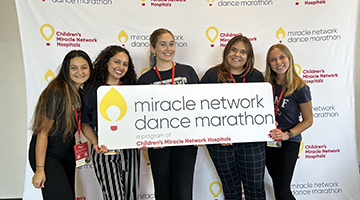 The Osprey Miracle team holding a 'miracle network dance marathon' sign
