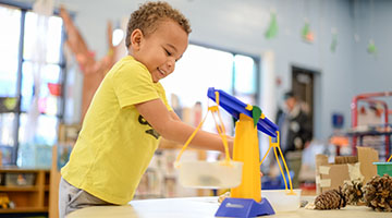 Pre-school student playing with a scale