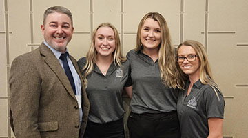 Three members from the undergraduate Kinesiology Quiz Bowl Team posing with club supervisor Dr. Michael Richardson