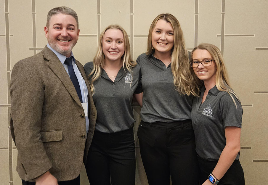 Three members from the undergraduate Kinesiology Quiz Bowl Team posing with club supervisor Dr. Michael Richardson