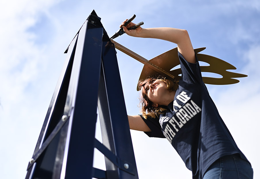 Sculpture student putting together the catfish windmill in the sculpture park