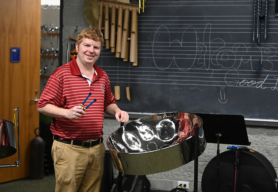 Shaun Bennett standing next to a steelpan