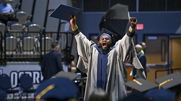 UNF graduate cheering with his diploma