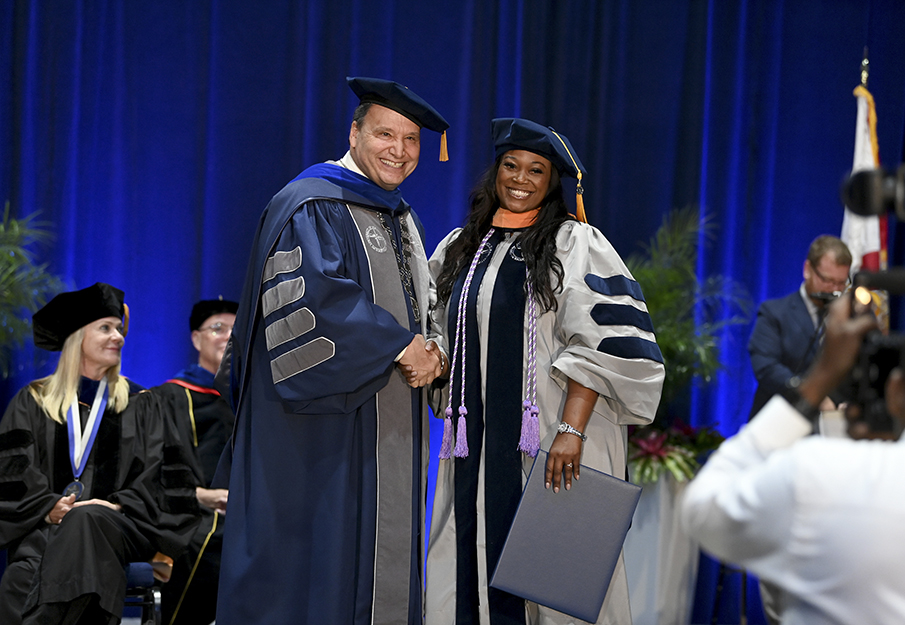 President Limayem shaking hands with graduate student