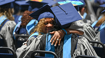 UNF grad hugging another UNF grad