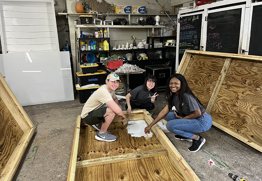 Three international students working on a prop for the Jacksonville Zoo and Gardens