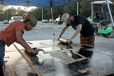 Students rolling ink/paint on a woodblock