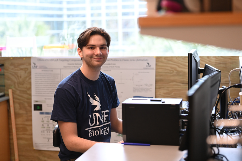 UNF biology student Alexander Bartkowiak sitting at a computer